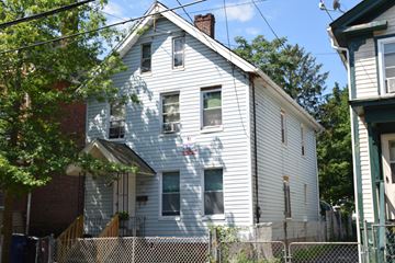New Haven apartment for rent - A white house with a brown roof and a fence in front.