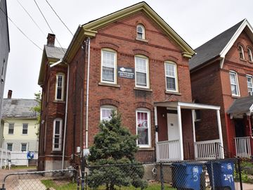 New Haven apartment for rent - A red brick house with a white door and windows.