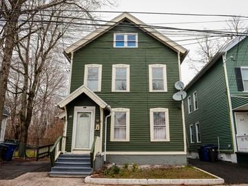 New Haven apartment for rent - A green house with a white door and windows.