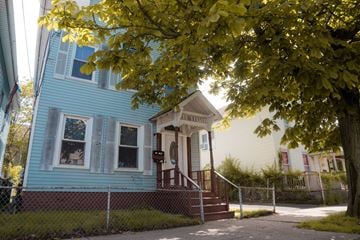 New Haven apartment for rent - A blue house with a white porch and a tree in front.