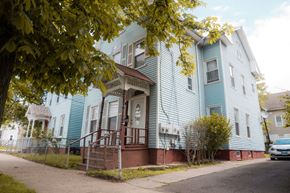 New Haven apartment for rent - A blue house with a tree in front.