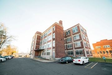 New Haven apartment for rent - A parking lot with cars and a building in the background.