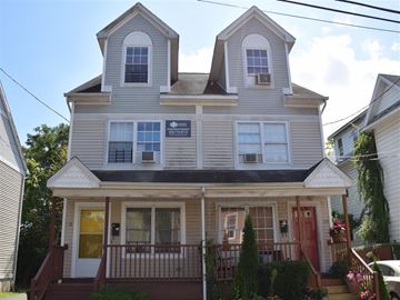 New Haven apartment for rent - A two-story house with a red door and a balcony.