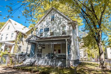 New Haven apartment for rent - A house with a porch and a tree in front of it.