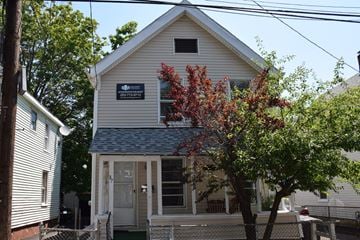 New Haven apartment for rent - A small house with a porch and a tree in front.