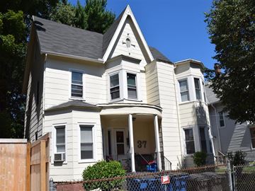 New Haven apartment for rent - A two-story house with a white facade and a black roof.