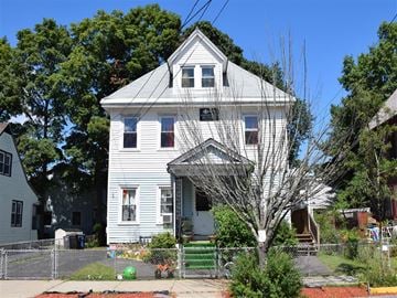 New Haven apartment for rent - A white house with a grey roof and a tree in front.