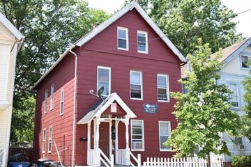 New Haven apartment for rent - A red house with a white picket fence in front.