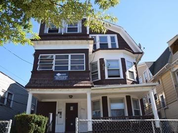 New Haven apartment for rent - A brown and white two story house with a white fence in front.