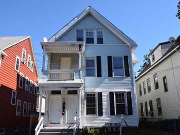 New Haven apartment for rent - A white house with a balcony sits between a red house and a beige house.