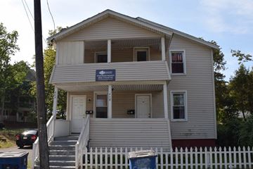 New Haven apartment for rent - A two-story house with a white picket fence in front.