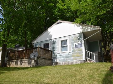 New Haven apartment for rent - A house with a white and blue exterior is surrounded by trees.