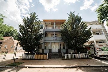 New Haven apartment for rent - A two-story house with a front porch and a truck parked in front.