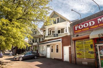 New Haven apartment for rent - A street view with a car parked in front of a building with a sign that says "Food M".