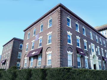 New Haven apartment for rent - A red brick building with white trim and awnings.
