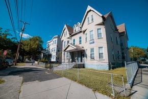 New Haven apartment for rent - A large, two-story house with a fenced front yard.