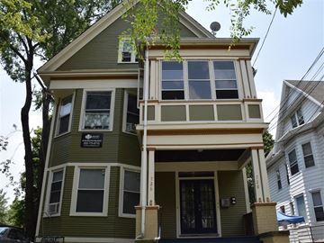 New Haven apartment for rent - A green two-story house with a balcony on the second floor.