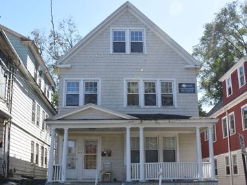 New Haven apartment for rent - A white house with a porch and a sign on the front.