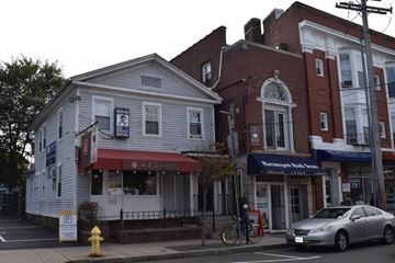 New Haven apartment for rent - A white building with a red awning is next to a red brick building.