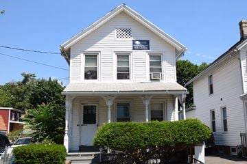 New Haven apartment for rent - A white house with a porch and a sign on the front.