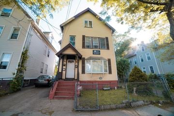 New Haven apartment for rent - A yellow house with a red staircase in front.