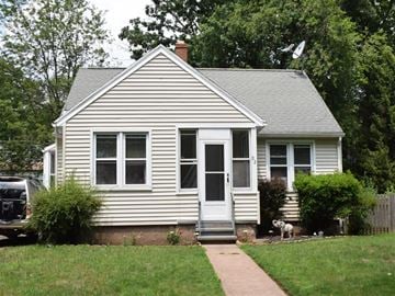 New Haven apartment for rent - A small white house with a grey roof and a grey door.