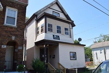 New Haven apartment for rent - A house with a brown and white exterior and a black sign on the front.