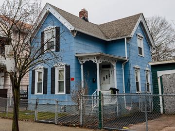 New Haven apartment for rent - A blue house with a white door and a fence in front.