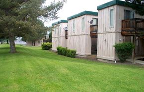 John Day apartment for rent - a row of wooden buildings with trees and grass