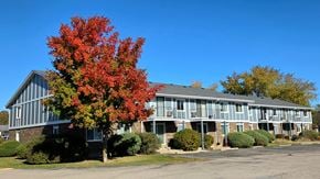 Kenosha apartment for rent - A tree with red leaves stands in front of a building.