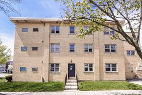 Skokie apartment for rent - a brick building with a blue door and a tree