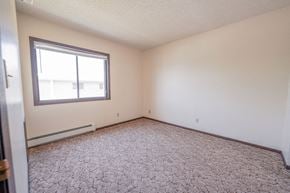 Ames apartment for rent - a bedroom with a large window and a carpeted floor