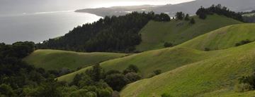 Novato apartment for rent - A landscape with rolling hills and a body of water in the distance.