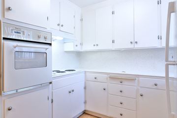 San Jose apartment for rent - a kitchen with white cabinets and a stove and a refrigerator