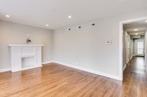 Chicago apartment for rent - a living room with white walls and a fireplace and wooden floors