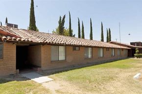 Delano apartment for rent - a brown house with a yard and trees