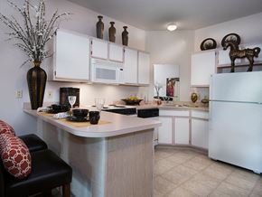 Grandview apartment for rent - a kitchen with white cabinets and a counter top and a refrigerator