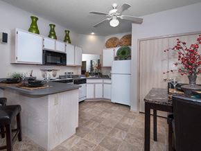 Bentonville apartment for rent - a kitchen with white appliances and a dining area with a table