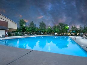 Bentonville apartment for rent - a swimming pool at night with a cloudy sky above it