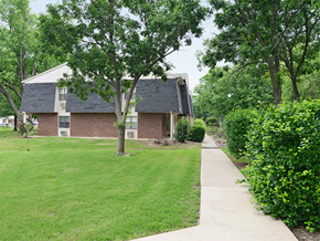 Bentonville apartment for rent - a brick house with a yard and a sidewalk