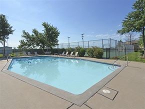 Joplin apartment for rent - a swimming pool with chairs around it next to a fence
