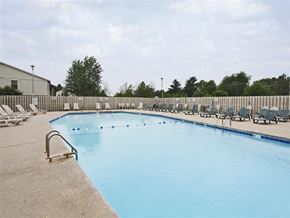 Rogers apartment for rent - a swimming pool with chairs and a fence around it