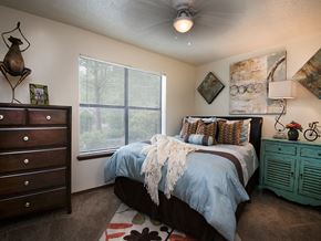 Rogers apartment for rent - a bedroom with a bed and a dresser and a ceiling fan