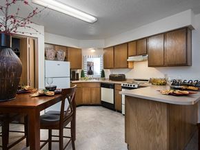 Rogers apartment for rent - a kitchen with wooden cabinets and a table with chairs