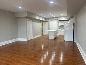 Manayunk triplex for rent - A kitchen with white appliances and wooden floors.