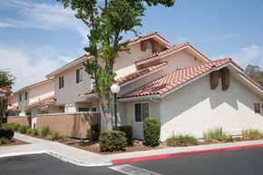 Fresno apartment for rent - a white house with a street and a tree in front of it