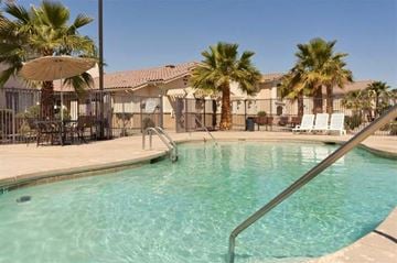 Somerton apartment for rent - a swimming pool with chairs and palm trees
