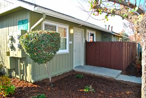Fresno apartment for rent - the front door of a green house with a tree in front of it