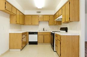 Porterville apartment for rent - a kitchen with wooden cabinets and a stove and a sink