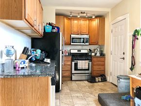 Chicago apartment for rent - a kitchen with wooden cabinets and a black refrigerator